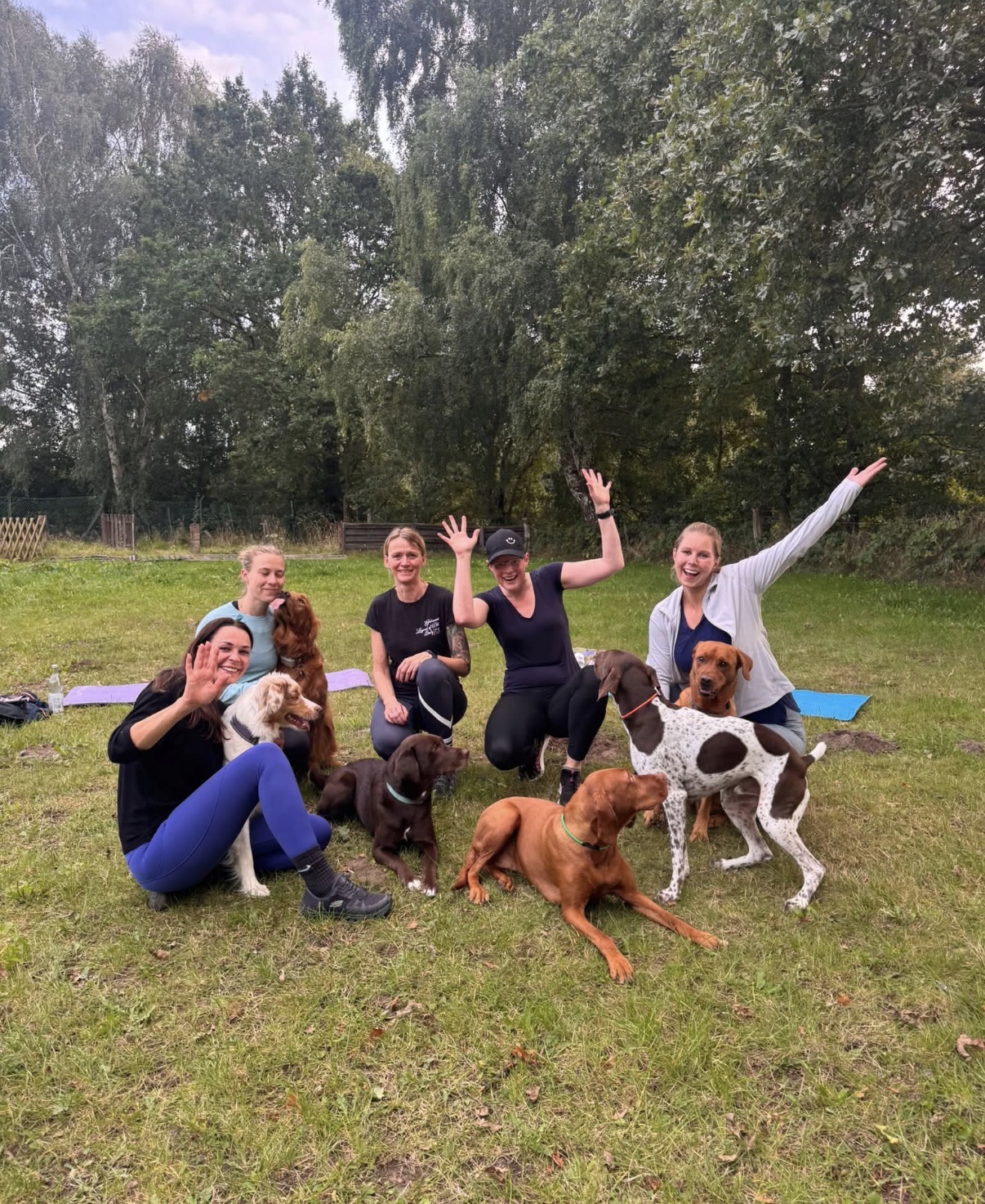 Fit-mit-Hund-Trainerinnen mit ihren Hunden beim gemeinsamen Training im Grünen